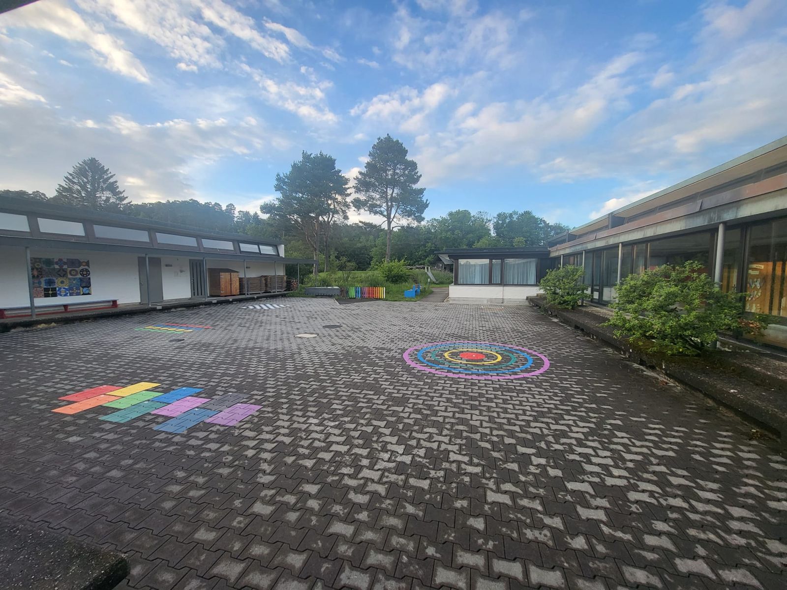 Pausenplatz des Schulhauses Heerenweg mit aufgemalten Spielfeldern vor den weissen Schulgebäuden