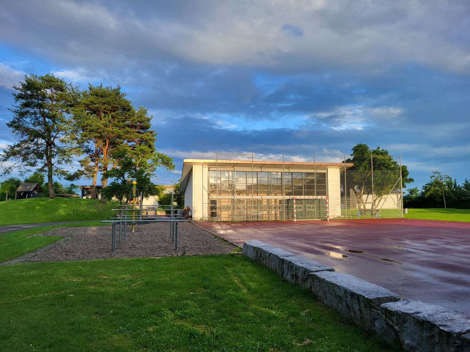 Turnhalle mit rotem Allwetterplatz