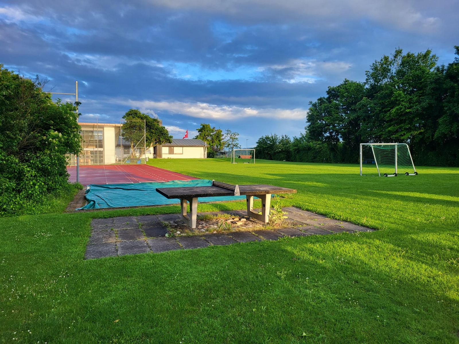 Sportwiese mit Fussballtor und Pingpongtisch vor der Turnhalle